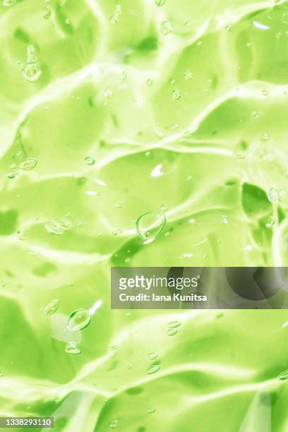 antibacterial aloe vera gel with bubbles. transparent green smudged of liquid moisture serum for face. hydrating hyaluronic acid. cosmetic products for skincare. cosmetology. vertical. - gel foto e immagini stock