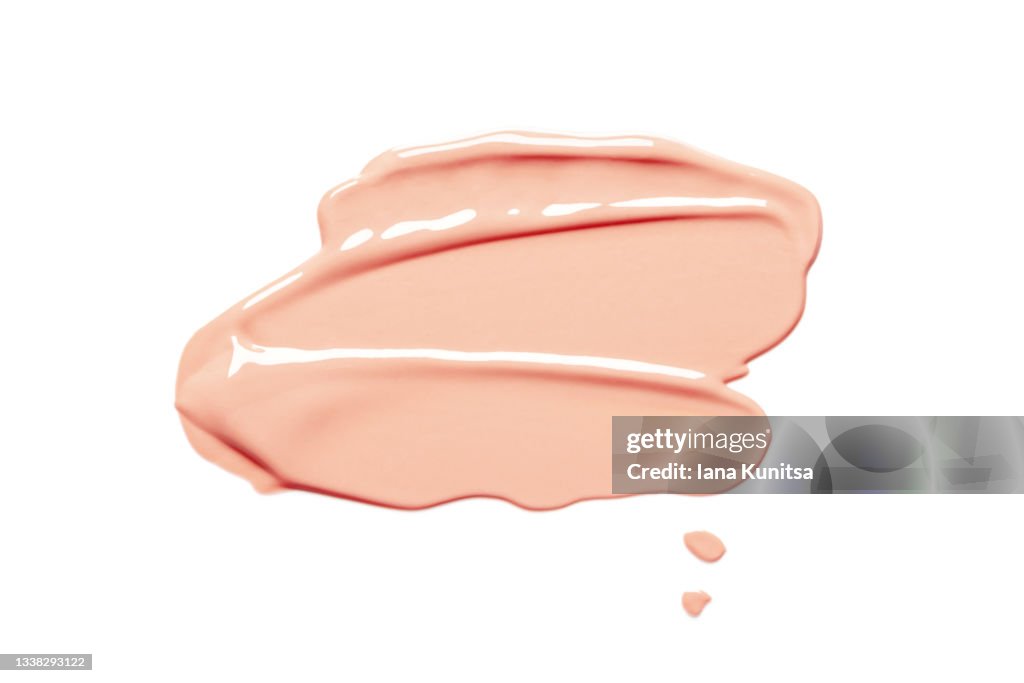 Beautiful delicate pink smear of BB face cream on white background isolated. Tonal Foundation is smudged. Products for makeup and skin care. Organic cosmetics. Cosmetology. Closeup.