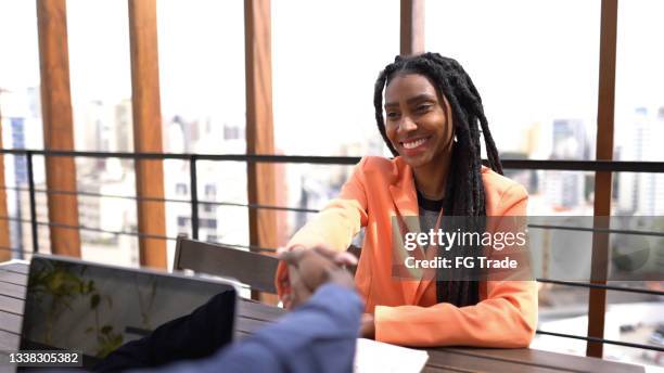 donna d'affari che stringe la mano all'uomo d'affari durante l'incontro sul tetto - african american interview foto e immagini stock