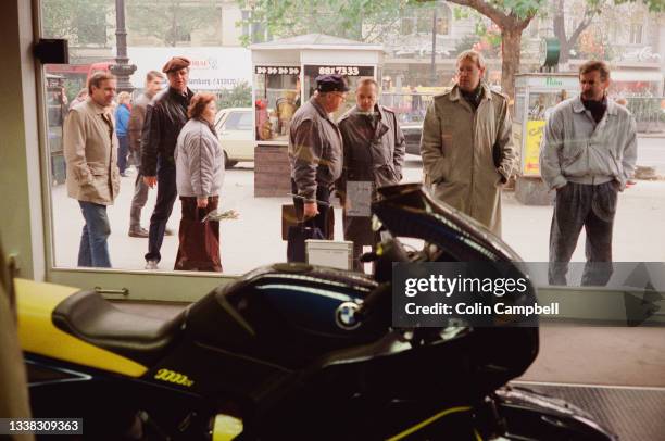 Berliners from West and East Berlin look inside a building window, Berlin, Germany, 10th November 1989.