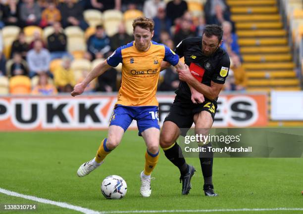 Stephen Quinn of Mansfield Town is challenged by Rory McArdle of Harrogate Town during the Sky Bet League Two match between Mansfield Town and...