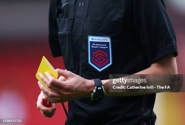 Detailed view of the FAWSL logo patch on the referees shirt and yellow card during the Barclays FA Women's Super League match between Aston Villa...