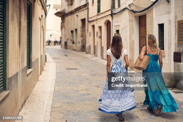 mother and daughter walking in the narrow streets of beautiful spanish town - pollensa imagens e fotografias de stock
