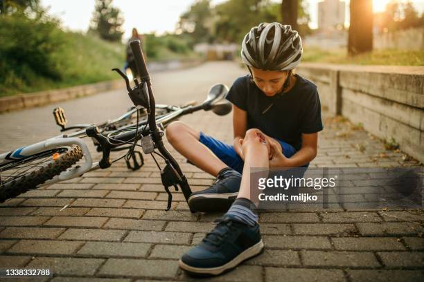 niño herido tras caerse de la bicicleta - leg wound fotografías e imágenes de stock