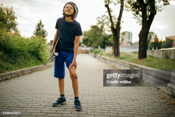 injured boy after falling down from skateboard - figure skater stockfoto's en -beelden