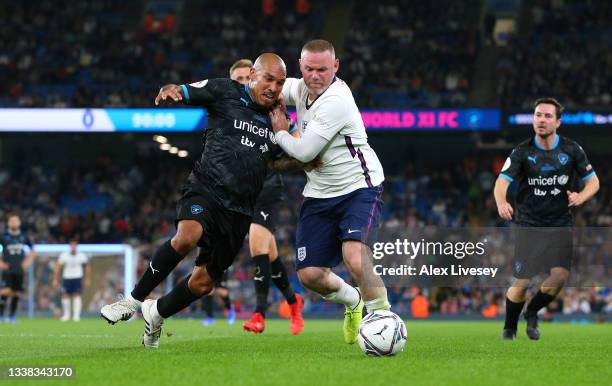 Wayne Rooney of England is tackled by Nigel De Jong of Soccer Aid World XI during Soccer Aid for Unicef 2021 match between England and Soccer Aid...