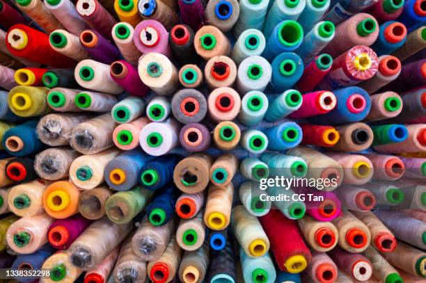 large group of variation colourful sewing thread spool in small business work place studio - linhas texteis imagens e fotografias de stock