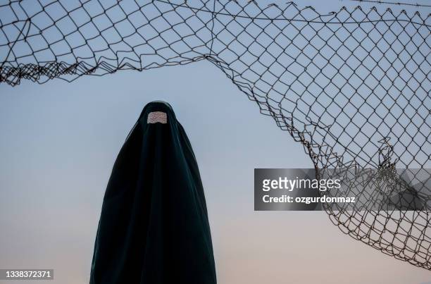 refugee woman in burka standing behind a fence - human head stock pictures, royalty-free photos & images