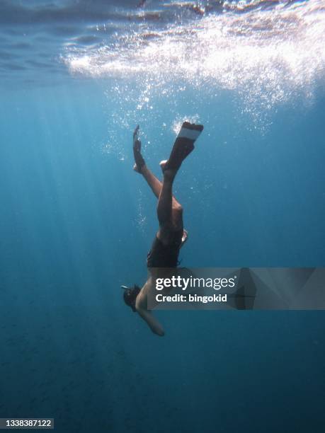 man with snorkel diving under the sea surface - person diving stock pictures, royalty-free photos & images