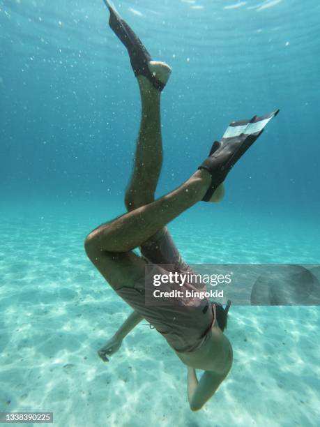 man floating underwater - board shorts stock pictures, royalty-free photos & images