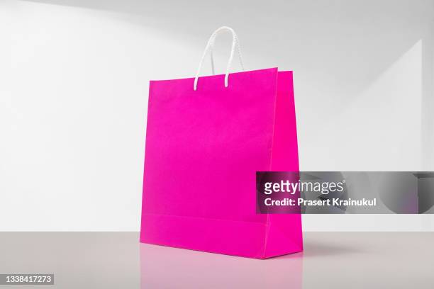 pink shopping bag on a white background - shopping centre ad stock pictures, royalty-free photos & images