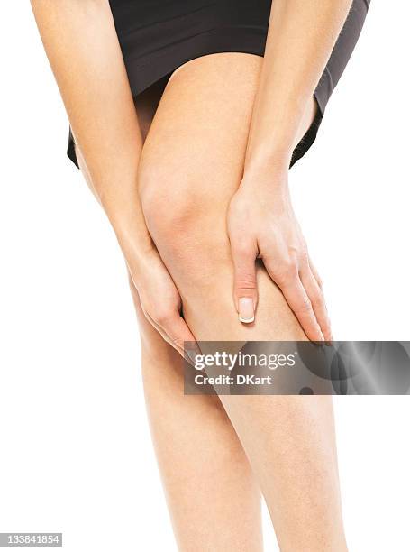 a woman holding her knee in pain - varicose vein stock pictures, royalty-free photos & images