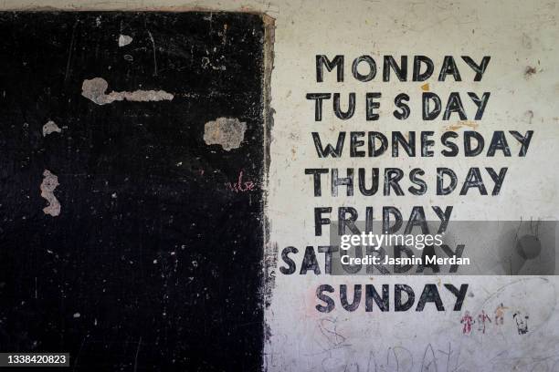 school wall in tanzania with days of the week - day of the week stockfoto's en -beelden