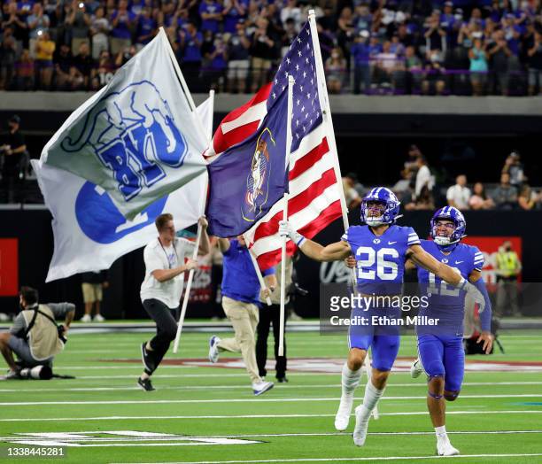 Defensive back Mitchell Price and wide receiver Puka Nacua of the Brigham Young Cougars lead the team onto the field before the Good Sam Vegas...
