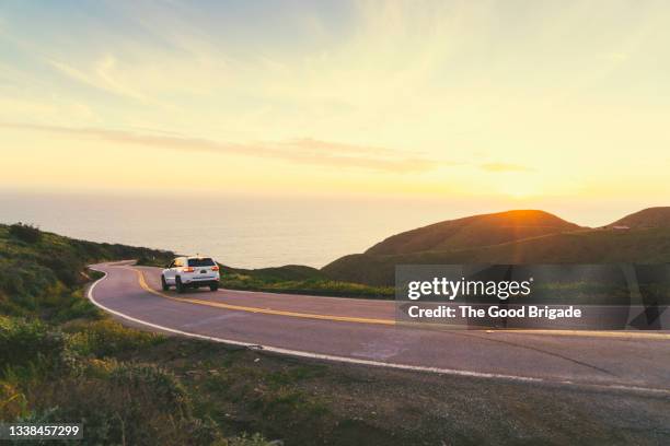 car on road against sky during sunset - suv fotografías e imágenes de stock
