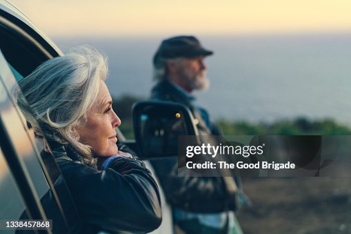 Mature woman sitting in car during sunset Mature woman sitting in car during sunset