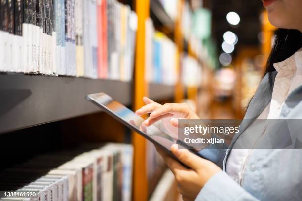 women using digital tablet in library - digital library stock pictures, royalty-free photos & images