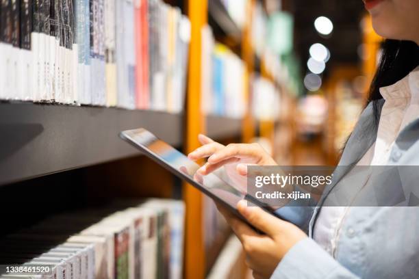 women using digital tablet in library - wireless technology stock pictures, royalty-free photos & images