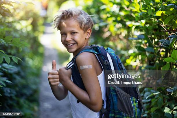 portrait of a vaccinated teenage boy going to school - summer school stockfoto's en -beelden