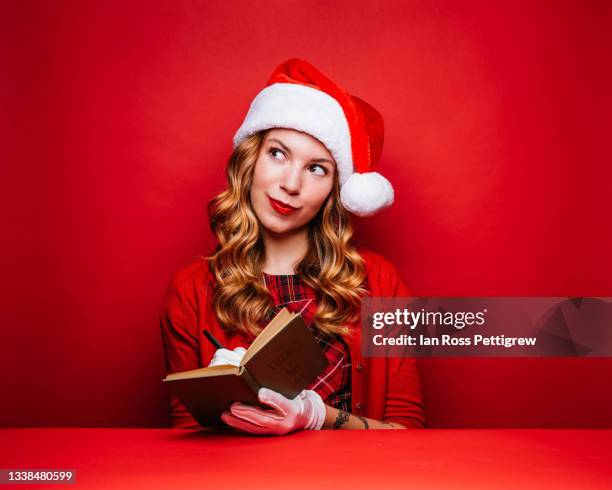 female santa's helper with naughty list - christmas list stock-fotos und bilder
