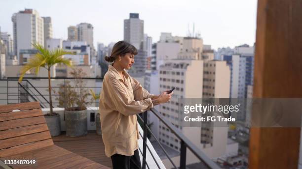 young woman using smartphone outdoors - bel appartement stockfoto's en -beelden