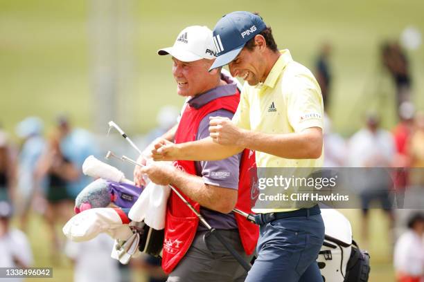 Joaquin Niemann of Chile and caddie Gary Mathews celebrate after finishing on the 18th green during the final round of the TOUR Championship on...