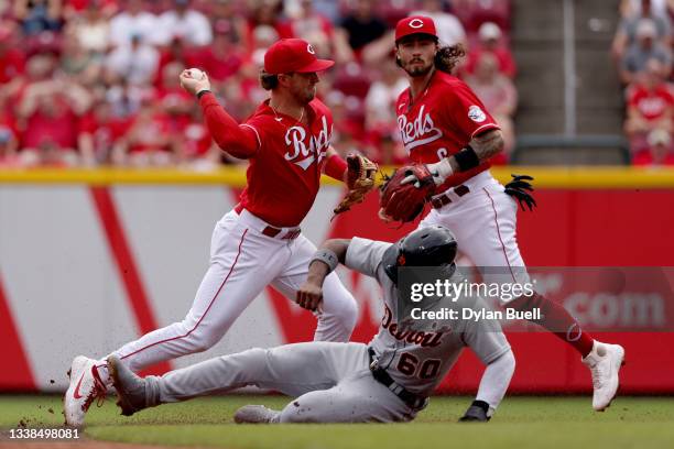 Kyle Farmer of the Cincinnati Reds turns a double play past Akil Baddoo of the Detroit Tigers in the third inning at Great American Ball Park on...