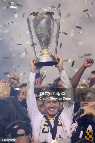 David Beckham of the Los Angeles Galaxy celebrates with the Philip F. Anschutz Trophy after defeating the Houston Dynamo 1-0 in the 2011 MLS Cup at...