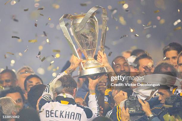 David Beckham of the Los Angeles Galaxy celebrates with the Philip F. Anschutz Trophy after defeating the Houston Dynamo 1-0 in the 2011 MLS Cup at...