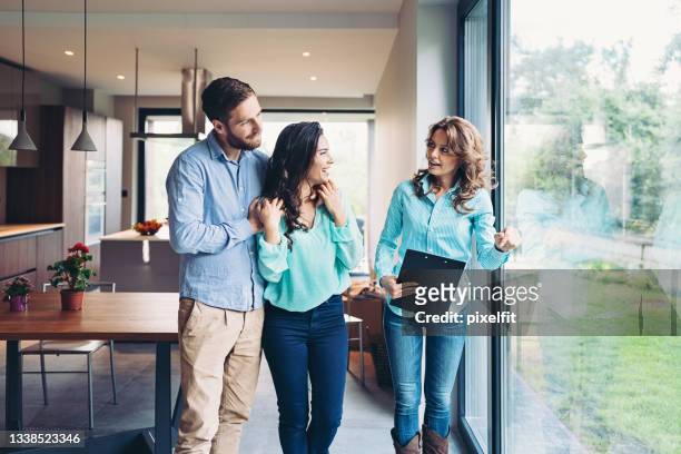 lovely young couple choosing home - real estate agent stock pictures, royalty-free photos & images