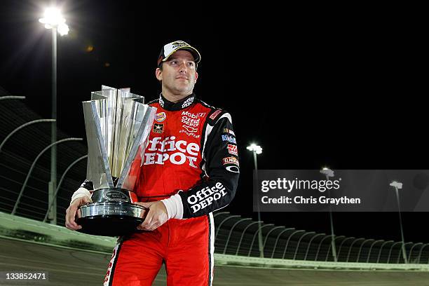 Tony Stewart, driver of the Office Depot/Mobil 1 Chevrolet, poses with the Championship trophy after winning the NASCAR Sprint Cup Series Ford 400...