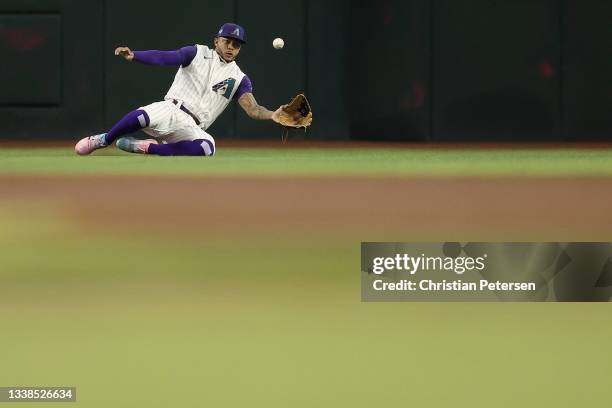 Outfielder Ketel Marte of the Arizona Diamondbacks makes a sliding catch during the frist inning of the MLB game against the Seattle Mariners at...