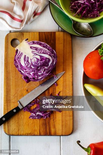 chopped red cabbage on wooden cutting board. - purple cabbage stock pictures, royalty-free photos & images