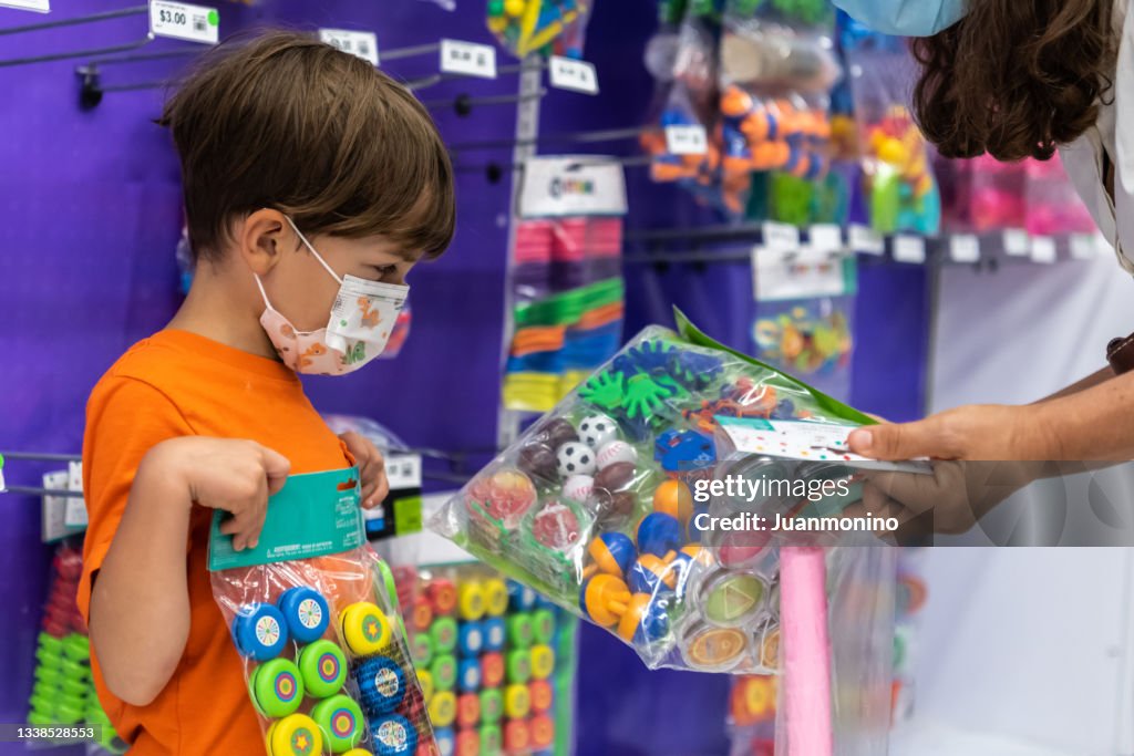 Kleiner Junge, der Spielzeug für seine Piñata-Geburtstagsfeier kauft