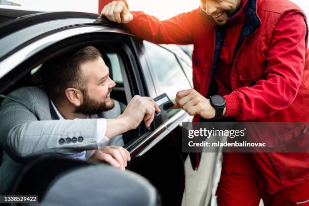 hombre pagando con tarjeta de crédito en la gasolinera - gas pump fotografías e imágenes de stock