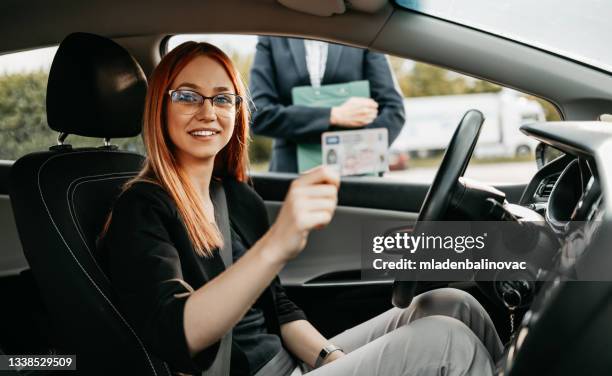 driving school or test. beautiful young woman learning how to drive car together with her instructor. - learning to drive stock pictures, royalty-free photos & images