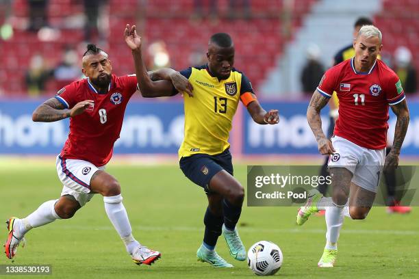 Enner Valencia of Ecuador competes for the ball with Arturo Vidal and Eduardo Vargas of Chile during a match between Ecuador and Chile as part of...