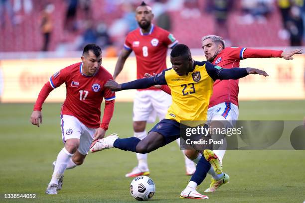 Moises Caicedo of Ecuador competes for the ball with Gary Medel and Diego Valdés of Chile during a match between Ecuador and Chile as part of South...