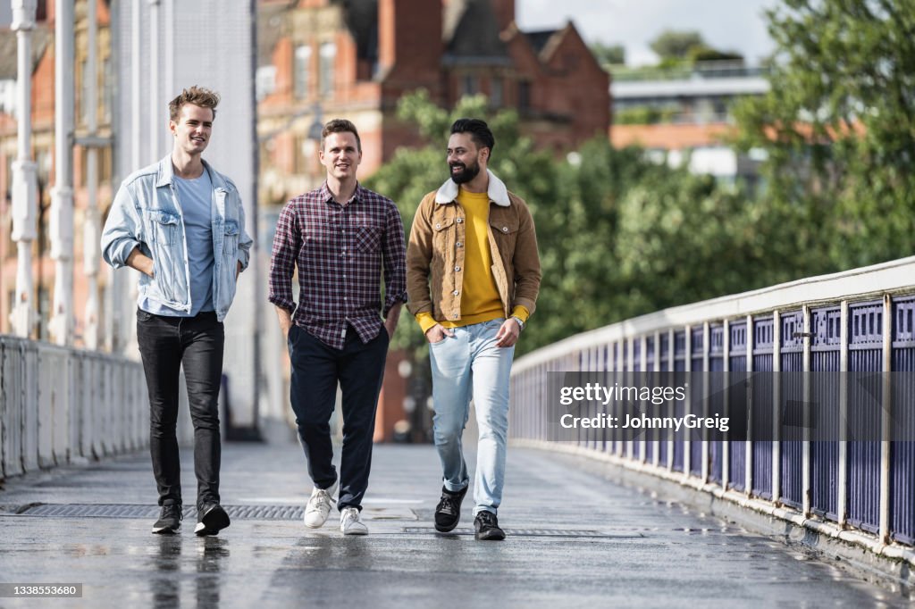 Männer genießen sonnigen Wochenendspaziergang über die Chelsea Bridge