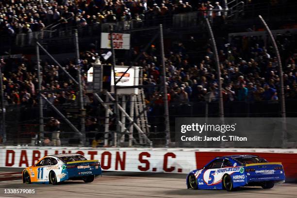 Denny Hamlin, driver of the Offerpad Toyota, leads Kyle Larson, driver of the HendrickCars.com Chevrolet, to the finish line to win the NASCAR Cup...