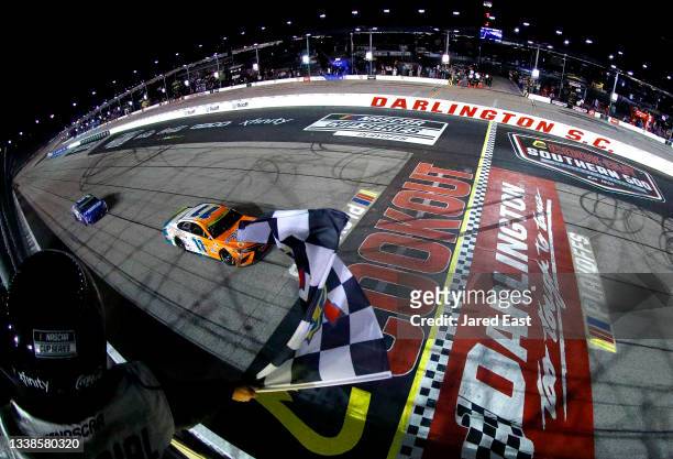 Denny Hamlin, driver of the Offerpad Toyota, takes the checkered flag to win the NASCAR Cup Series Cook Out Southern 500 at Darlington Raceway on...