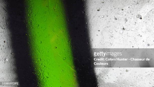 green and black lines painted on a gray wall - graffiti wand stock-fotos und bilder