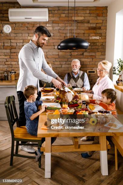 extended family having thanksgiving lunch in dining room. - happy family eating stock pictures, royalty-free photos & images