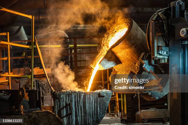 pouring of liquid molten metal to casting mold using forklift - metaalindustrie stockfoto's en -beelden