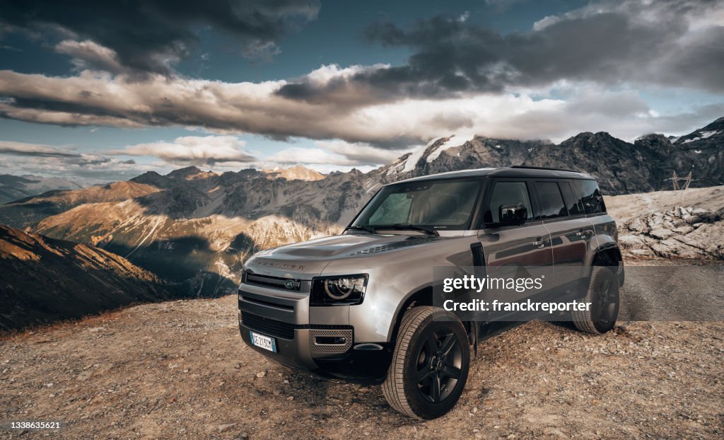 Land Rover Defender against the alps at Passo dello Stelvio close to Bormio