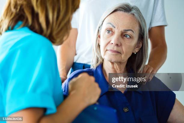 worried senior woman talking with nurse - paralysis stock pictures, royalty-free photos & images