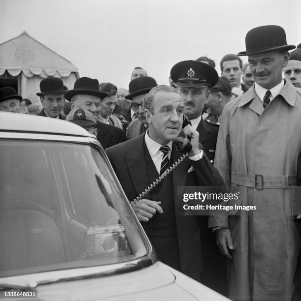 The Minister of Transport, Ernest Marples, using a police car's radio telephone to order the barriers to be removed on the M1 at the opening ceremony...