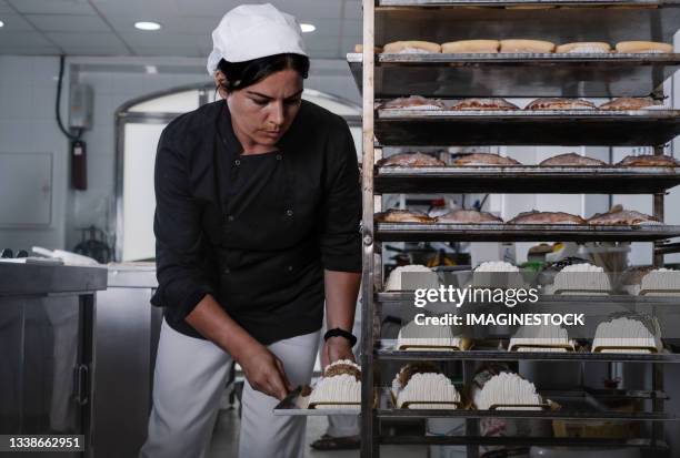 young woman making delicious cakes in the pastry shop - boulangerie industrielle photos et images de collection