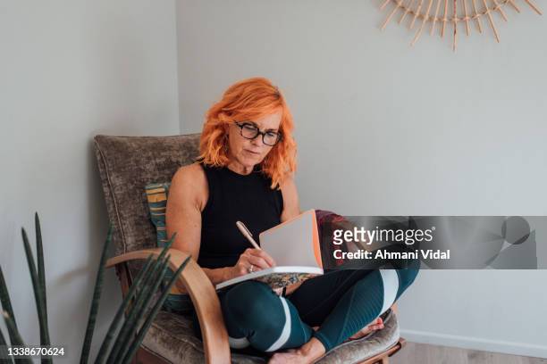 pilates instructor journaling at home - older woman colored hair stock pictures, royalty-free photos & images