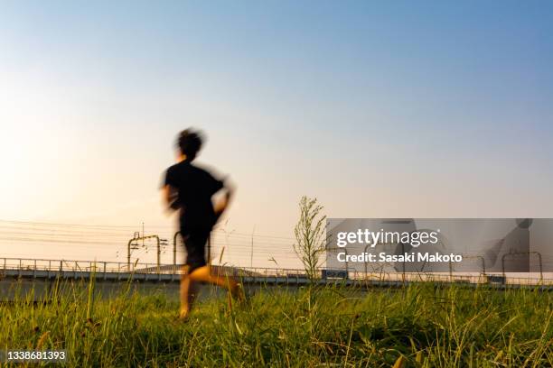 people crossing the riverbed before sunset - blurred running sunset stock-fotos und bilder